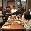 A full cupping table surrounded by roasters, café owners and buyers tasting Ugandan coffee