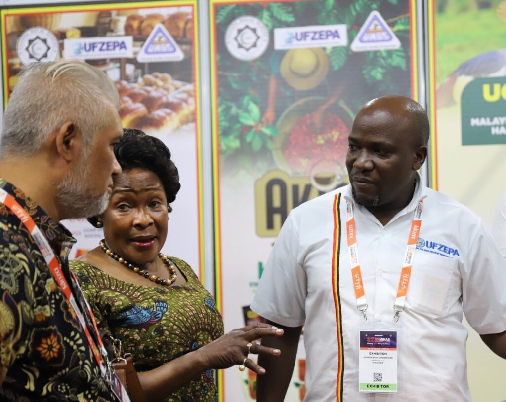 Uganda High Commission representatives and a UFZEPA exhibitor in conversation with a visitor at the Uganda stand at MIHAS 2026