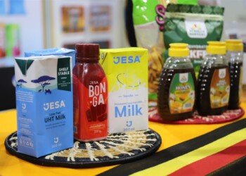 Jesa UHT milk, Bonga drink and bottled honey displayed on a Uganda flag cloth at MIHAS 2026