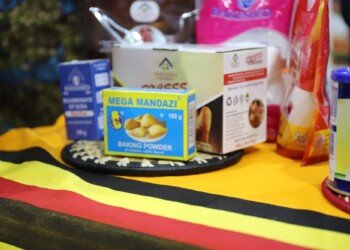 Ugandan packaged foods and baking products arranged on a Uganda flag cloth