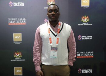 A Ugandan delegate at the World Halal Business Conference backdrop in Kuala Lumpur