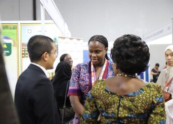 Members of the Uganda delegation speaking with guests at the showcase